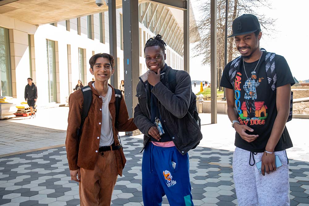 3 students pose for photo on UMB campus